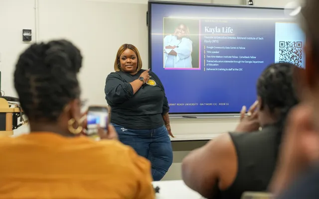 Kayla Life presenting beside a screen introducing her as facilitator at Grant Ready University, Baltimore CIC, Room 02